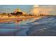 Sunset view of a busy ocean beach and architecture reflecting in the wet sand at 505 67Th Ave # 11, St Pete Beach, FL 33706