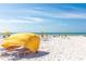 Picturesque beach view with yellow sunshades, beachgoers, and clear blue skies and ocean waters at 505 67Th Ave # 11, St Pete Beach, FL 33706