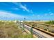 Beach boardwalk with wooden railing leads to the sandy beach and ocean under a clear blue sky at 505 67Th Ave # 11, St Pete Beach, FL 33706