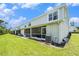 Rear exterior view of townhomes featuring screened in patios and green backyards on a sunny day at 5501 67Th N Ave # 11, Pinellas Park, FL 33781