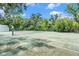 Outdoor tennis court surrounded by lush trees offering residents recreational opportunities at 5501 67Th N Ave # 11, Pinellas Park, FL 33781