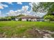 Exterior image of a spacious backyard with lush grass and surrounding mature trees with a view of the pool at 6123 India Dr, Spring Hill, FL 34608