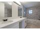 Modern bathroom featuring a double sink vanity, tiled accent wall, and sleek fixtures creates a luxurious, spa-like atmosphere at 6123 India Dr, Spring Hill, FL 34608