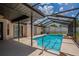 View of the in-ground pool with screened-in lanai featuring neutral tones, tile accents, and a private space at 6123 India Dr, Spring Hill, FL 34608