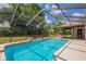A sparkling in-ground pool and screened-in patio offer a private outdoor retreat perfect for relaxing and entertaining at 6123 India Dr, Spring Hill, FL 34608