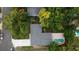 Aerial view of the home showcasing the roof, driveway, pool, and surrounding trees at 6332 Emerson S Ave, St Petersburg, FL 33707