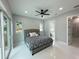 Bright bedroom features tile floors, a ceiling fan, a large window, and access to a bathroom and walk-in closet at 6332 Emerson S Ave, St Petersburg, FL 33707