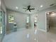 Bright primary bedroom featuring tile flooring, a ceiling fan, and ensuite bathroom and walk-in closet access at 6332 Emerson S Ave, St Petersburg, FL 33707