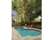 Secluded backyard features a beautiful kidney-shaped pool, mature trees, and a wooden fence at 6332 Emerson S Ave, St Petersburg, FL 33707
