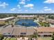 Aerial view of townhomes surrounding a lake and community pool at 6400 46Th N Ave # 61, Kenneth City, FL 33709