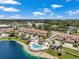 A serene aerial view showcases the community's pool, lake, and well-maintained exteriors on a bright, sunny day at 6400 46Th N Ave # 61, Kenneth City, FL 33709
