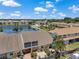 Aerial view of townhomes surrounding a lake and a community pool with a cabana at 6400 46Th N Ave # 61, Kenneth City, FL 33709