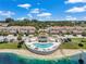 Aerial view features a lakeside community pool and cabana with palm trees at 6400 46Th N Ave # 61, Kenneth City, FL 33709