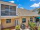 Backyard view featuring a screen porch, patio, and well-maintained landscaping at 6400 46Th N Ave # 61, Kenneth City, FL 33709