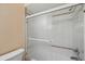 Bathroom featuring a shower-tub combo with a sliding glass door and tiled walls at 6400 46Th N Ave # 61, Kenneth City, FL 33709