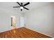 Bedroom with ceiling fan, wood-look flooring and a view of the ensuite bathroom at 6400 46Th N Ave # 61, Kenneth City, FL 33709