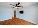Bedroom featuring wood flooring, a ceiling fan, and a wall mounted TV at 6400 46Th N Ave # 61, Kenneth City, FL 33709