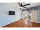Bedroom with wood flooring, ceiling fan, balcony access, and a wall mounted TV at 6400 46Th N Ave # 61, Kenneth City, FL 33709