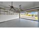Bright garage showcasing painted walls, ceiling fan, and convenient shelving at 6400 46Th N Ave # 61, Kenneth City, FL 33709