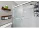 Shower features a glass door, safety bars, and mounted shelves at 6400 46Th N Ave # 61, Kenneth City, FL 33709