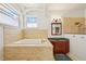Bathroom showcasing a built-in tub, granite countertop vanity, and arched windows at 6543 Louise Ct, Hudson, FL 34667
