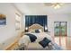 Cozy bedroom with access to a balcony and a luxurious bed adorned with blue accents at 6543 Louise Ct, Hudson, FL 34667