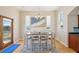 Dining area with ample light, contemporary table, balcony access, complemented by kitchen proximity at 6543 Louise Ct, Hudson, FL 34667