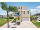 Charming three-story home with garage, multiple balconies, and lush tropical landscaping in a waterfront community at 6543 Louise Ct, Hudson, FL 34667