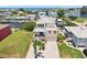 Bright two-story waterfront home with a brick driveway, lush lawn, balcony, and canal views at 6543 Louise Ct, Hudson, FL 34667