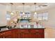 Kitchen with center island, black countertops, hardwood floors, cherry wood cabinetry, and view to living area at 6543 Louise Ct, Hudson, FL 34667