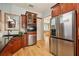Updated kitchen featuring stainless steel appliances, cherry wood cabinetry, black countertops, and hard wood floors at 6543 Louise Ct, Hudson, FL 34667