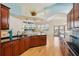 Bright kitchen features cherry wood cabinetry, black granite countertops, tile backsplash, hardwood floors, and open concept living area at 6543 Louise Ct, Hudson, FL 34667