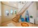 Light and airy foyer with wooden staircase, beach-themed decor, hardwood floors, and plenty of natural light at 6543 Louise Ct, Hudson, FL 34667
