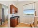 Wet bar featuring dark countertops, mini fridge, and scenic outdoor views at 6543 Louise Ct, Hudson, FL 34667