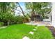 An inviting backyard with lush green lawn, screened in patio, and mature trees, offering a perfect outdoor space at 6921 N 16Th St, Tampa, FL 33610