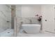 Elegant bathroom featuring a freestanding tub, walk-in shower, and marble-look tile at 6921 N 16Th St, Tampa, FL 33610