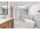 Sleek bathroom features a soaking tub, skylight, a walk-in shower and modern finishes at 6921 N 16Th St, Tampa, FL 33610