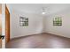 This bedroom features wood floors, a ceiling fan and black framed double hung windows at 6921 N 16Th St, Tampa, FL 33610