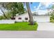 Charming single-story home featuring a manicured lawn, white siding, and red window shutters at 6921 N 16Th St, Tampa, FL 33610