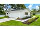 Charming home with a well-manicured lawn and a white exterior with a driveway to the garage at 6921 N 16Th St, Tampa, FL 33610