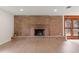 Living area showcasing a brick fireplace, hardwood floors, and lots of natural light at 6921 N 16Th St, Tampa, FL 33610