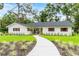 Charming single-story home featuring a yellow front door, red shutters, and well-manicured landscaping at 6921 N 16Th St, Tampa, FL 33610
