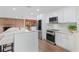 Modern kitchen features white cabinets, stainless steel appliances, and a marble countertop at 6921 N 16Th St, Tampa, FL 33610