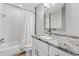 Updated bathroom with granite countertop, white cabinets, and a shower-tub combo at 7210 14Th N St, St Petersburg, FL 33702