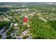 Aerial view showcases property boundaries outlined in red; surrounded by lush greenery and neighborhood homes at 7211 Red Oak Loop, New Port Richey, FL 34654