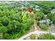Property's expansive green land is showcased in this aerial view, marked by red boundaries amidst a lush environment at 7211 Red Oak Loop, New Port Richey, FL 34654