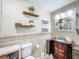 Charming bathroom with a unique vanity, decorative shelves, and tiled walls at 7211 Red Oak Loop, New Port Richey, FL 34654
