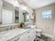 Bright bathroom featuring double sinks with marble counters, white cabinets, and decorative mirrors at 7211 Red Oak Loop, New Port Richey, FL 34654