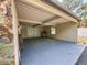 Covered carport area featuring a grill, storage area, and access to the backyard at 7211 Red Oak Loop, New Port Richey, FL 34654