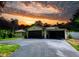 Exterior view of home with a dark garage, carport, and driveway, set against a dramatic sky at 7211 Red Oak Loop, New Port Richey, FL 34654
